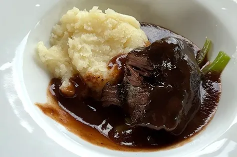 箸で切った柔らかい牛ほほ肉